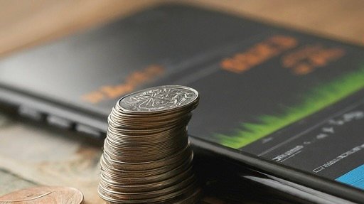 a stack of coins next to a phone